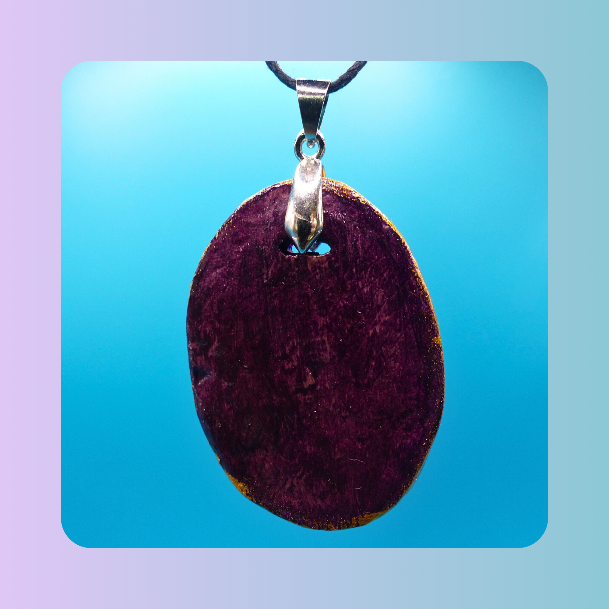 Dos du pendentif Petit Lien en argile autodurcissante, posé sur fond bleu. Vue sur l’attache qui accueille le cordon.