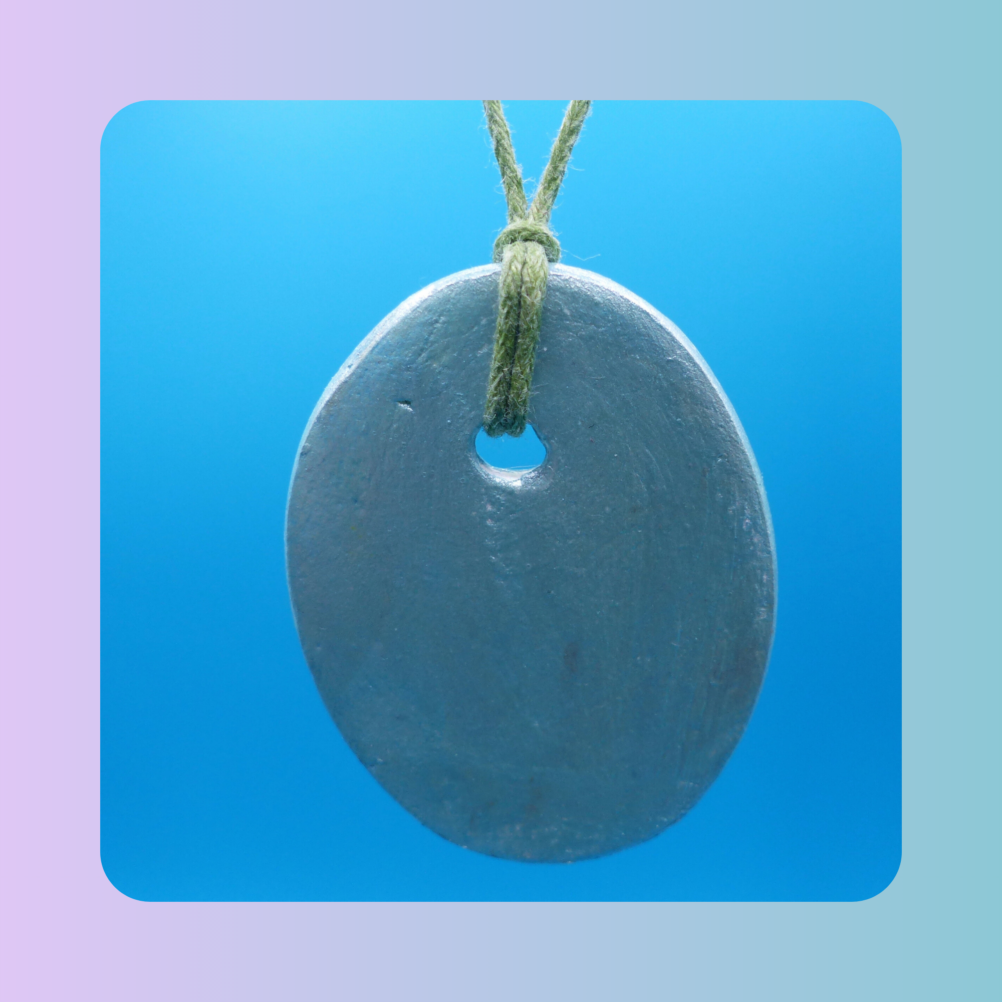 Dos du pendentif Petit Lien en argile autodurcissante, posé sur fond bleu. Vue sur l’attache qui accueille le cordon.