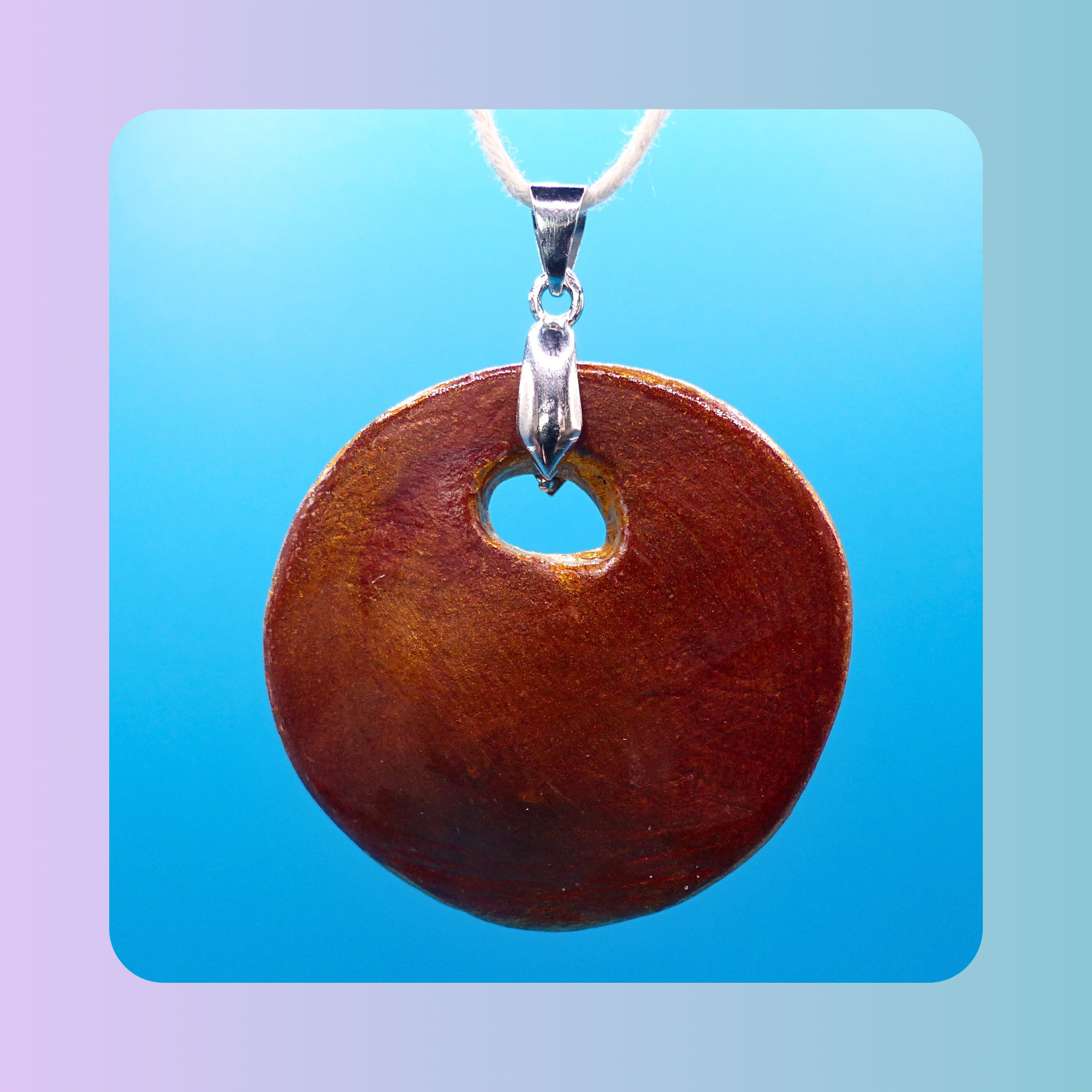 Dos du pendentif Petit Lien en argile autodurcissante, posé sur fond bleu. Vue sur l’attache qui accueille le cordon.